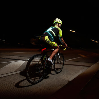 A person riding a bike at night with Tracer360 for added visibility.